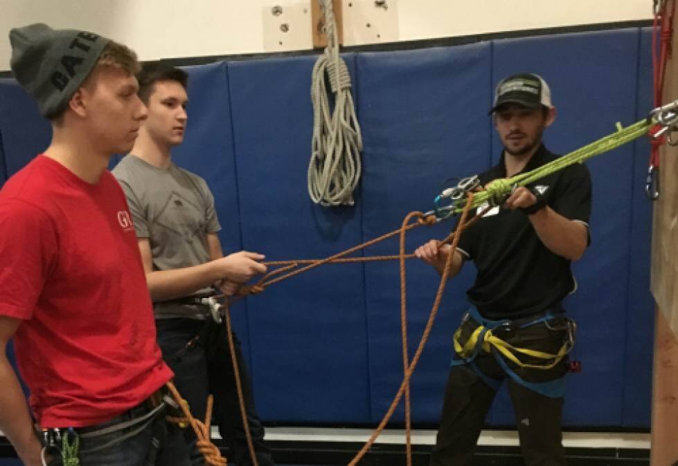 OA staff member teaches a technical anchor system to 2 students 